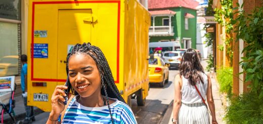 woman holding smartphone beside yellow box van