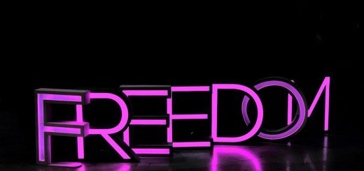 purple Freedom lighted freestanding letters on brown surface