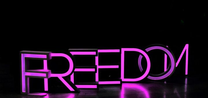 purple Freedom lighted freestanding letters on brown surface